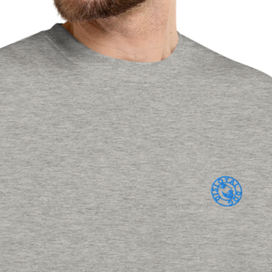 Close up image of a male in a grey Disloyal Dog branded sweater. The Disloyal Dog logo is embroidered in a lightish-blue colour.
