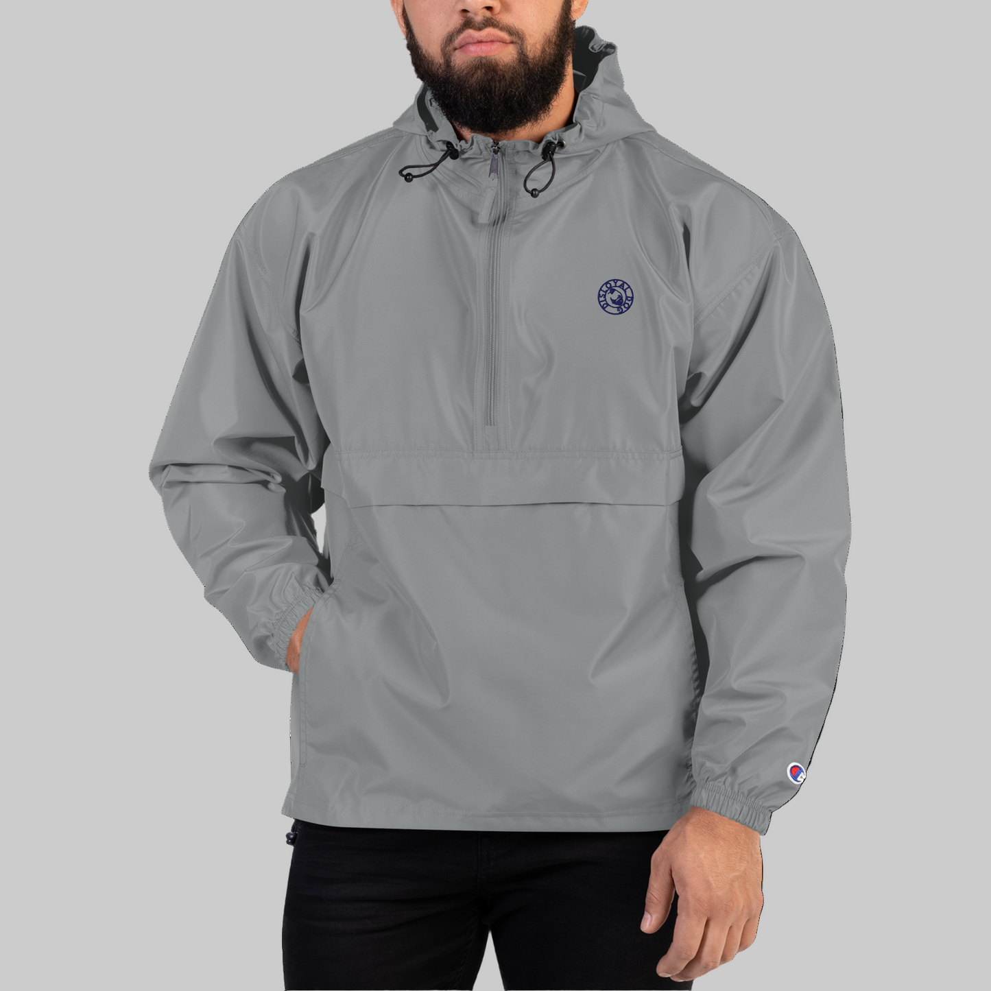 Man wearing a gray Disloyal Dog / Champion branded waterproof jacket with black draw chords at the hood.